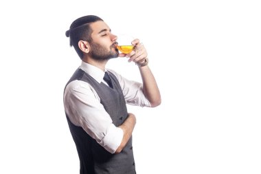 Bir bardak viski tutan yakışıklı sakallı işadamı. 