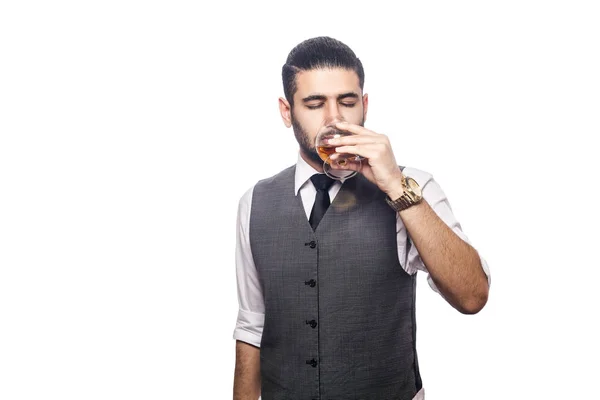 Hezký vousatý podnikatel drží sklenku whisky. — Stock fotografie