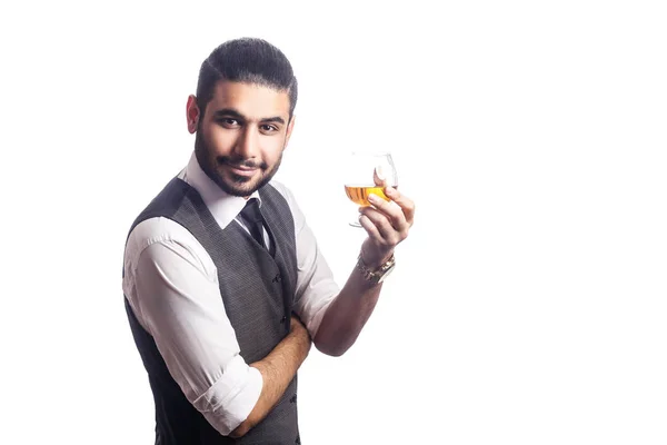Όμορφος γενειοφόρος επιχειρηματίας κρατώντας ένα ποτήρι ουίσκι. — Φωτογραφία Αρχείου