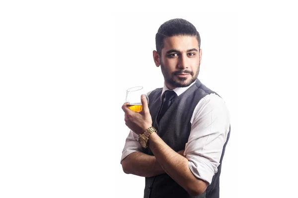 Hezký vousatý podnikatel drží sklenku whisky. — Stock fotografie