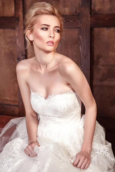 Moda beleza tiroteio nupcial. Bela noiva moda em vestido de noiva posando na frente de fundo amadeirado . — Fotografia de Stock