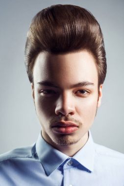 Retro klasik pompadour saç modeli ile genç adam portresi. Stüdyo vurdu. Kameraya bakarak.