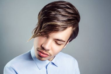Gözleri üzerinde uzun saçak saç modeli ile genç adam portresi. Stüdyo vurdu. clossed gözler.