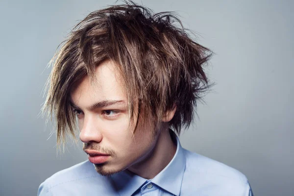 フリンジ乱雑な髪型を持つ若者の肖像画。スタジオ撮影. — ストック写真