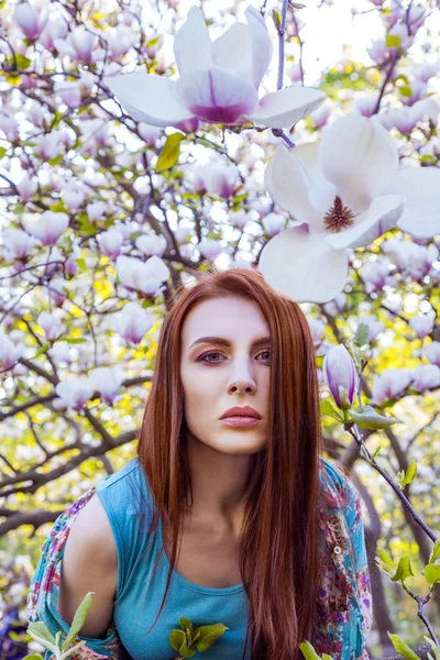Porträtt av ung vacker kvinna poserar bland blommande träd med rosa ögonskugga. — Stockfoto