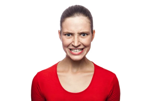 Retrato de una mujer enojada y preocupada con una camiseta roja con pecas. mirando a la cámara y gritando, filmado en el estudio. aislado sobre fondo blanco . — Foto de Stock