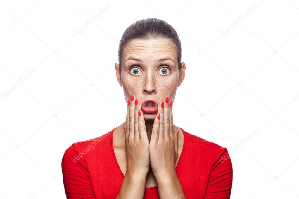 Portrait of happy surprised woman in red t-shirt with freckles. looking at camera excited with big eyes, studio shot. isolated on white background. 