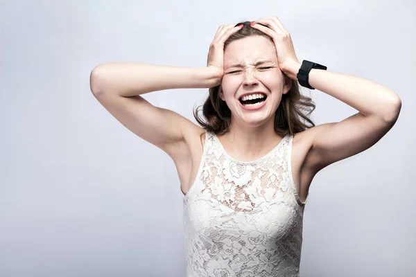 Retrato de mulher bonita com sardas e vestido branco e relógio inteligente com dor de cabeça no fundo cinza prata. conceito de saúde e medicina . — Fotografia de Stock