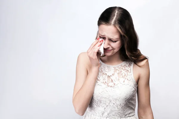 Portrait of sad, happily crying woman with freckles and white dress and smart watch on silver gray background. Salin ruang. konsep layanan kesehatan dan pengobatan . — Stok Foto