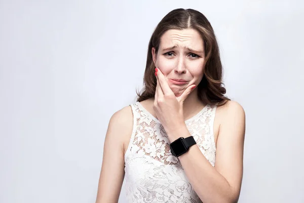 Potret wanita cantik dengan bintik-bintik dan gaun putih dan jam tangan pintar dengan sakit gigi di latar belakang abu-abu perak. konsep layanan kesehatan dan pengobatan . — Stok Foto