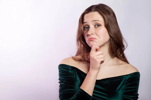 I don't know. Portrait of unhappy thoughtful woman with freckles and classic green dress. studio shot on silver gray background. — Stock Photo, Image