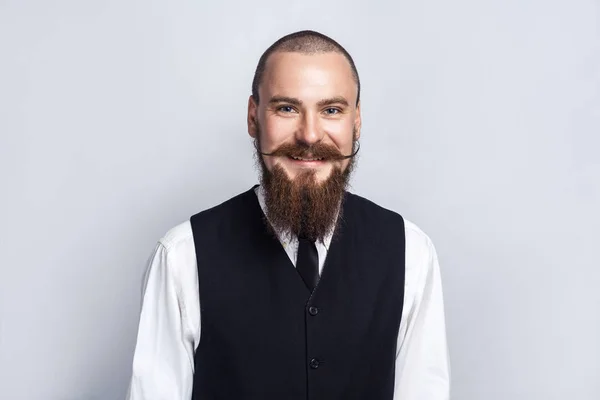 Le bonheur. Beau homme d'affaires avec barbe et moustache de guidon regardant la caméra avec le visage souriant de dents. plan studio, sur fond gris . — Photo