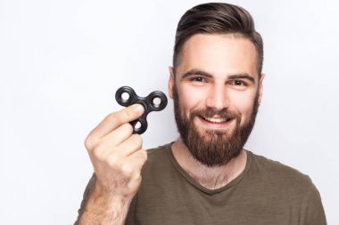 Young man holding and playing with fidget spinner. studio shot on white background. clipart