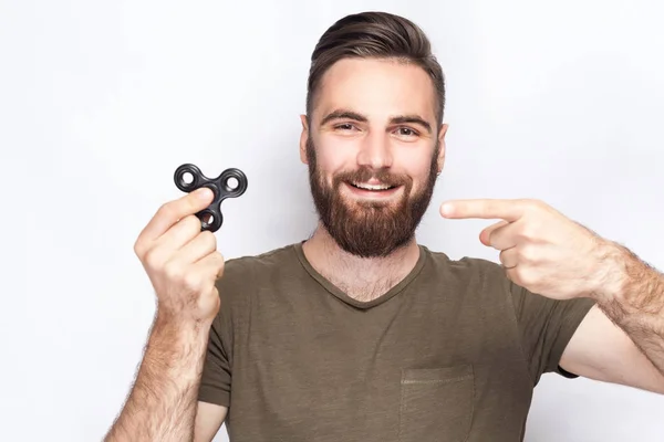 Jovem segurando e brincando com fidget spinner. estúdio tiro no fundo branco . — Fotografia de Stock