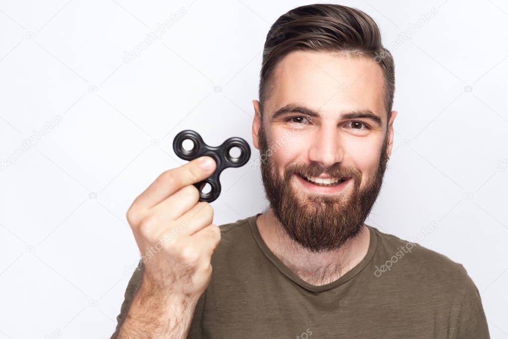 Young man holding and playing with fidget spinner. studio shot on white background.