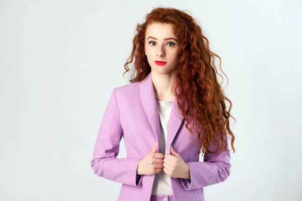 Portrait of successful happy beautiful business woman with red - brown hair and makeup in pink suit. looking at camera with smile,  studio shot on gray background. — Stock Photo, Image