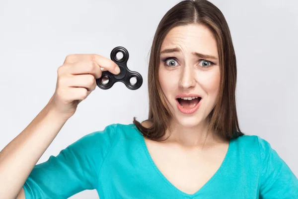 Ung vacker flicka holding och leker med fidget spinner. — Stockfoto