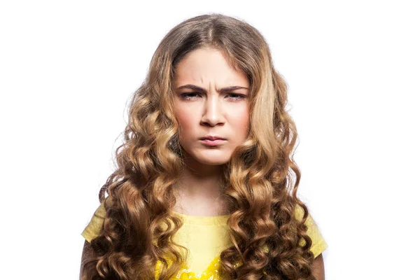 Retrato de chica enojada infeliz con peinado ondulado y camiseta amarilla. estudio disparo aislado sobre fondo blanco . — Foto de Stock