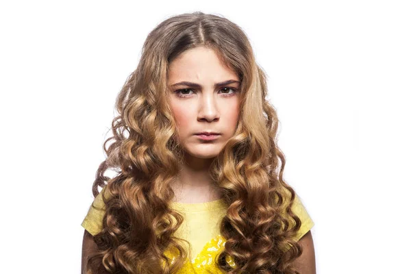 Porträt eines traurigen Mädchens mit welliger Frisur und gelbem T-Shirt. Studioaufnahme isoliert auf weißem Hintergrund. — Stockfoto
