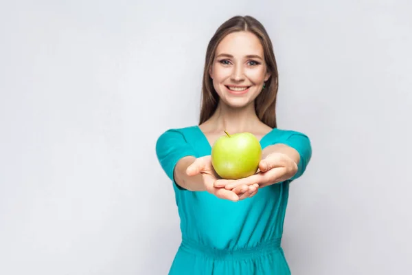 Jovem mulher bonita com sardas e vestido verde segurando maçã e compartilhar com sorriso . — Fotografia de Stock