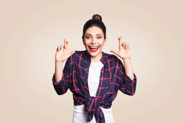 Retrato de menina bonita em estilo casual olhando para a câmera com pose mentirosa rindo. estúdio filmado em fundo bege . — Fotografia de Stock