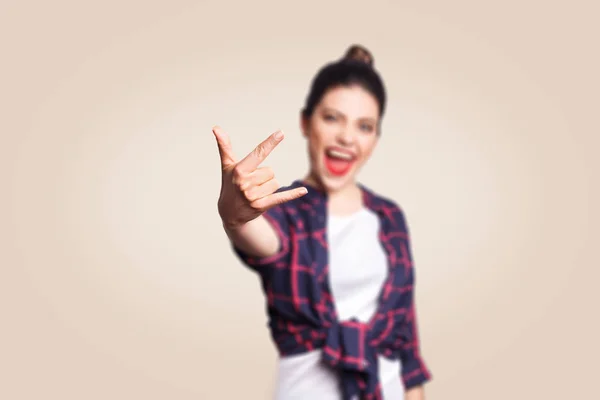 Sinal de rock. Feliz engraçado toothy sorridente jovem mulher mostrando sinal de rocha com os dedos. estúdio filmado em fundo bege. foco nos dedos . — Fotografia de Stock