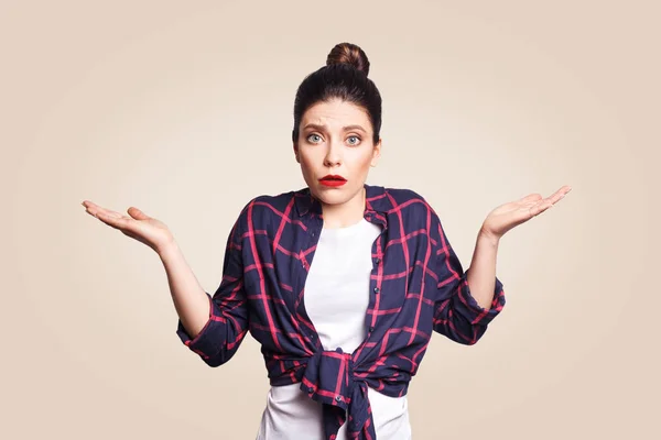 Retrato de una joven morena conmocionada con un estilo casual que parece desesperada o asustada, manteniendo la boca abierta y haciendo un gesto impotente con sus manos, no sabe qué hacer. . — Foto de Stock