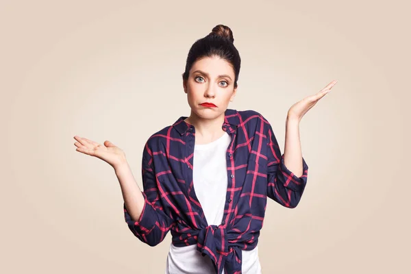 Puzzled and clueless young woman with arms out, shrugging her shoulders, saying: who cares, so what, I don't know. Negative human emotions, facial expressions, life perception and attitude. — Stock Photo, Image