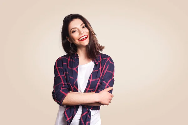 Retrato de bela menina feliz em estilo casual olhando para a câmera com sorriso de dente. estúdio filmado em fundo bege . — Fotografia de Stock