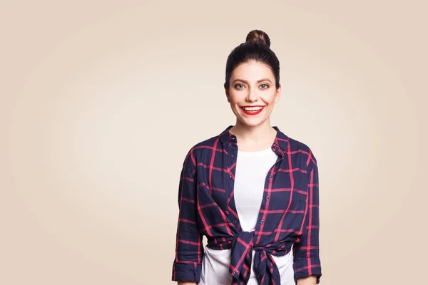 Retrato de bela menina feliz em estilo casual olhando para a câmera com sorriso de dente. estúdio filmado em fundo bege . — Fotografia de Stock