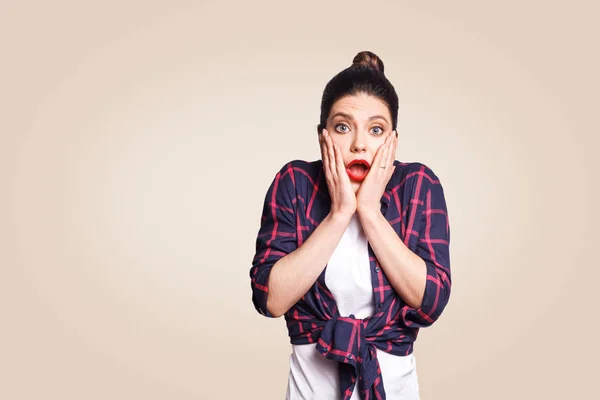 Portret van jonge wanhopige roodharige vrouw in casual stijl op zoek paniek, houden van haar hoofd met beide handen, met de mond wijd open. Vrouw in wanhoop en shock. — Stockfoto