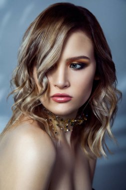 Beautful manken makyaj, renkli vawy saç modeli ve aksesuarlar boynunda Güzellik Portresi. mavi arka plan üzerinde atış stüdyo.