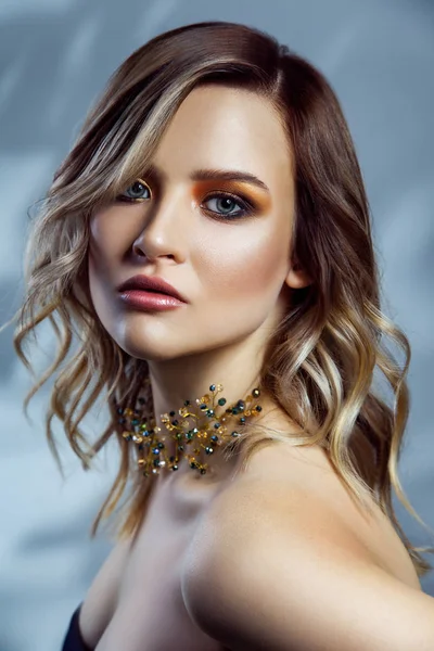 Retrato de beleza de modelo de moda bonita com maquiagem, penteado vawy colorido e acessórios em seu pescoço. estúdio filmado em fundo azul . — Fotografia de Stock