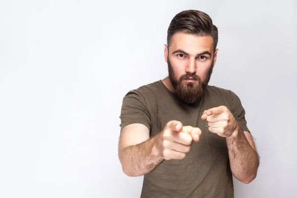 Hey You! Portrait of serious bearded man with dark green t shirt against light gray background. studio shot. — Stock Photo, Image