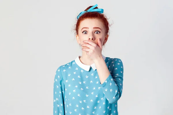 Kobieta w rozpaczy i szok. Portret młodego zdesperowany redhead dziewczyna w niebieskiej sukience patrząc paniki, objętych jej usta ręką. Na białym tle studio strzał na szarym tle. — Zdjęcie stockowe