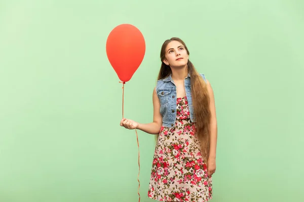 A bela adolescente loira sonhando, com balões vermelhos em um fundo verde. Estúdio isolado tiro — Fotografia de Stock