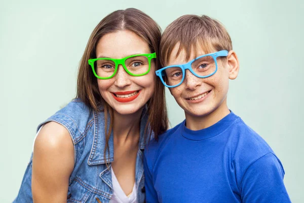 Concetto di occhiali. Stile hipster. Ritratto di splendido fratello e sorella lentigginoso in magliette casual indossando occhiali alla moda e posa su sfondo azzurro insieme. Studio girato — Foto Stock