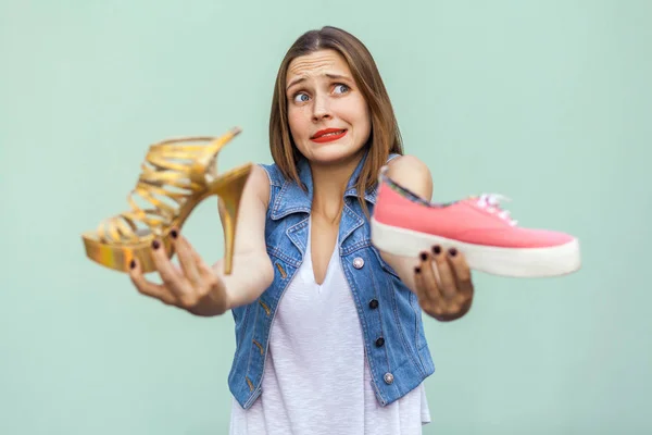 La hermosa chica con pecas en el centro comercial consiguió elegir zapatillas de deporte o zapatos guapos, pensando y mirando hacia arriba . —  Fotos de Stock