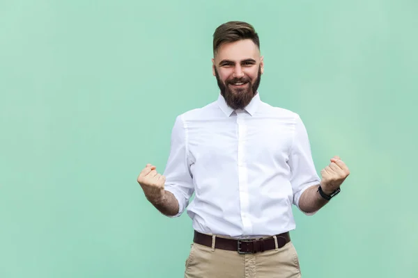 O empresário regozija-se pelo seu sucesso. Isolado em fundo verde claro. Interior, tiro estúdio — Fotografia de Stock