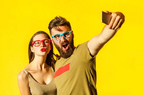 Τρελό selfie. Όμορφη φίλους macking selfie σε κίτρινο φόντο. Studio που γυρίστηκε Εικόνα Αρχείου