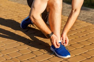 Ayakkabı bağcığı bağla. Mavi spor ayakkabıları. Runnig
