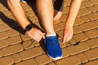 Ayakkabı bağcığı bağla. Mavi spor ayakkabıları. Spor