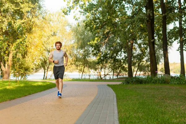 Rousse et taches de rousseur homme courir dans le parc — Photo