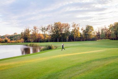 Sonbahar, Gölü golf sahası. Yeşil kaçan genç yetişkin kız