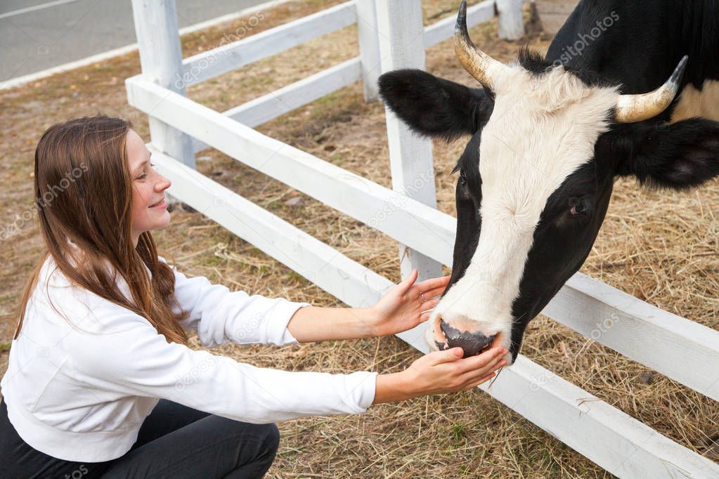 Portrait of woman working in barn. Smiling farmer woman standing by cattle outside.