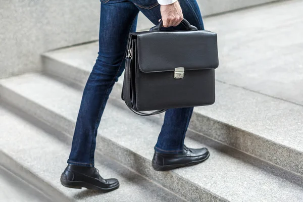 Empresario con maletín en la mano subiendo escaleras . — Foto de Stock