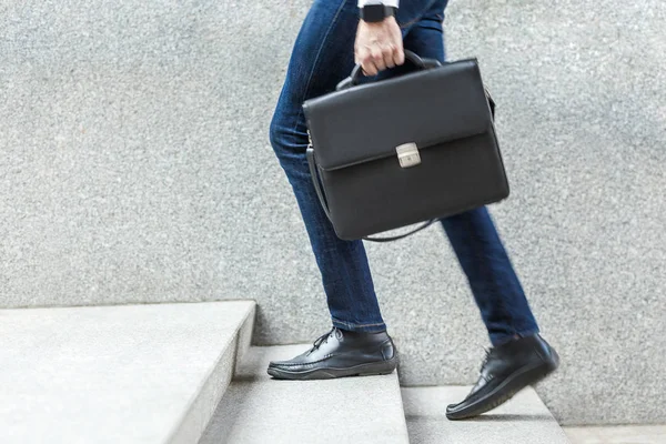 Empresario con maletín en la mano subiendo escaleras . — Foto de Stock