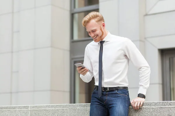 Redhead and bearded business man have a video conference in hes smart phone. Business concept. — Stock Photo, Image