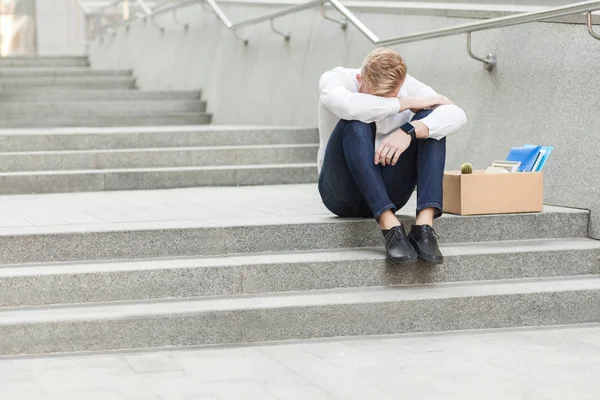 Unglückliche rote Haare und bärtiger Geschäftsmann, der mit Pappe sitzt, den Kopf löchert und traurig ist und weint. — Stockfoto