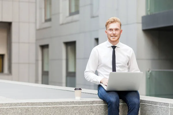 Young adult businessman working outsourcing, looking at camera and toothy smile. — Stock Photo, Image